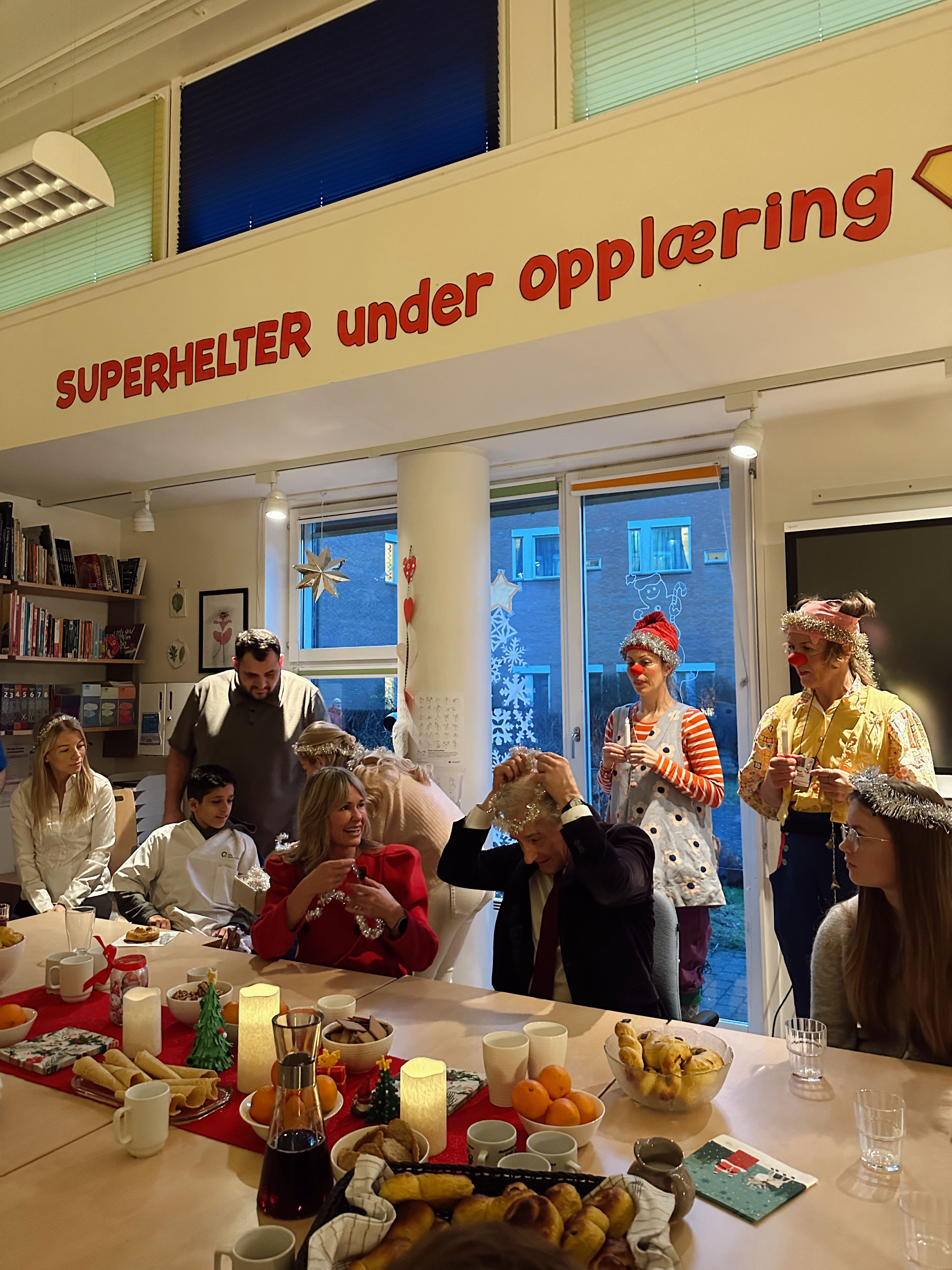 en gruppe mennesker som sitter ved et bord med mat og drikke