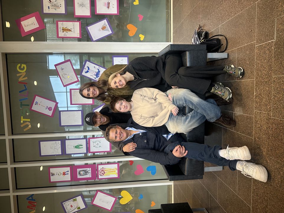 Foto: Marthe H. Thorsen en gruppe mennesker som sitter på en benk foran en butikk