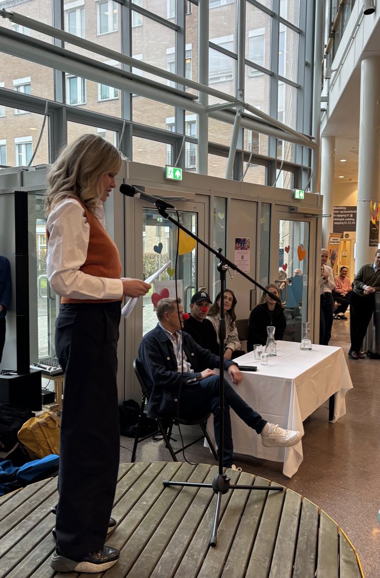 en person som står foran en gruppe mennesker som sitter ved et bord en person som står foran en gruppe mennesker som sitter ved et bord