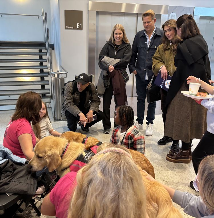 en gruppe mennesker som står rundt en hund en gruppe mennesker som står rundt en hund