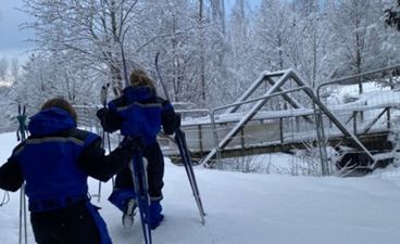 et par personer med ski i en snødekt bakke