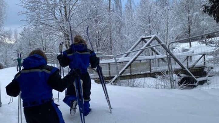 et par personer med ski i en snødekt bakke